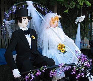Scarcrow bride in her wedding dress and scarecrow groom